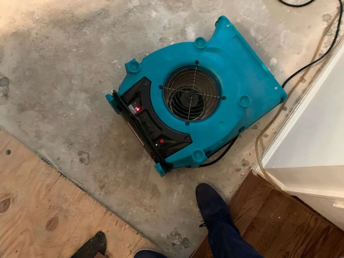 Air mover drying subfloor during Commercial Water Damage Restoration in Dartmouth